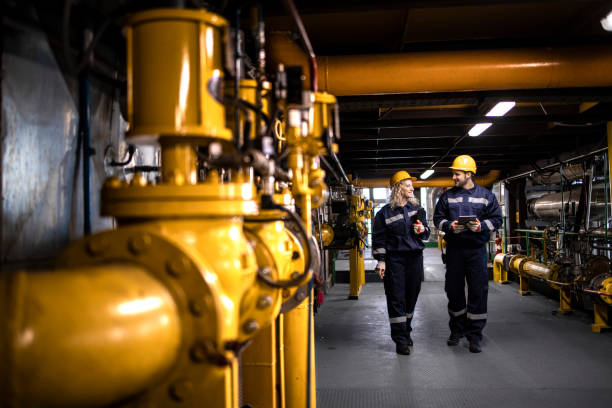 Workers walking along yellow pipeline infrastructure